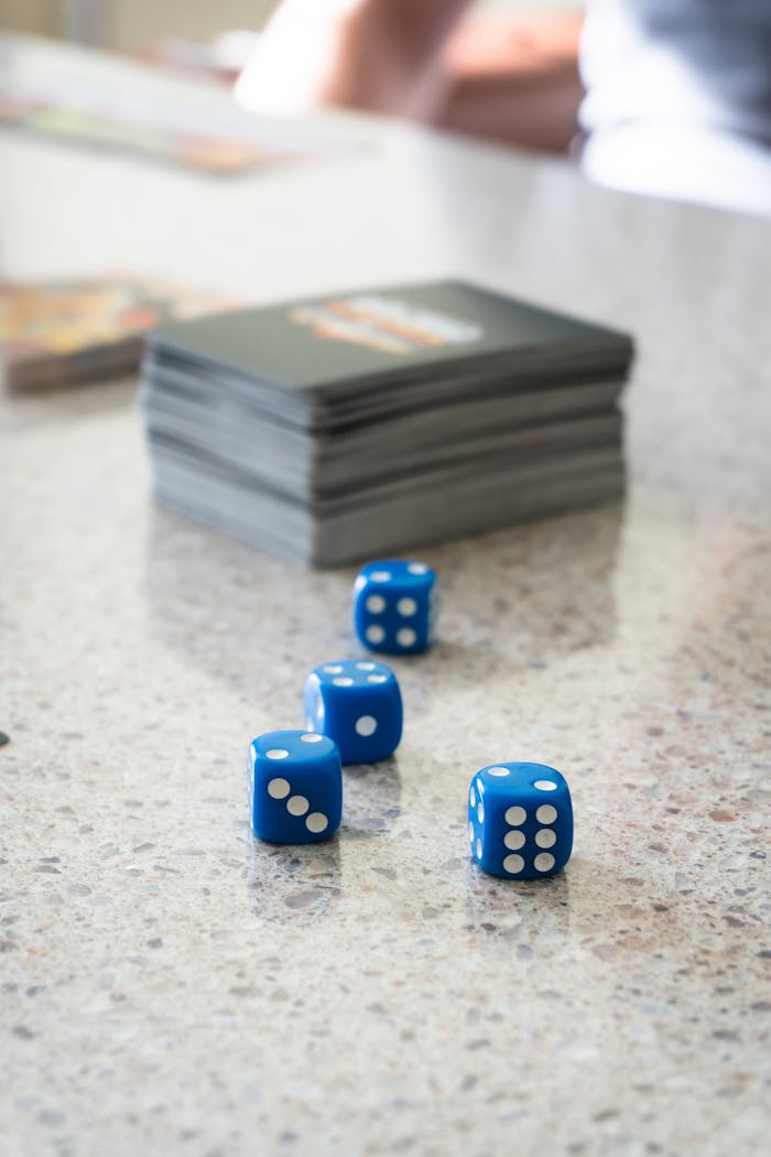 Close-up of blue dice and card stack on a marble table, perfect for gaming themes.